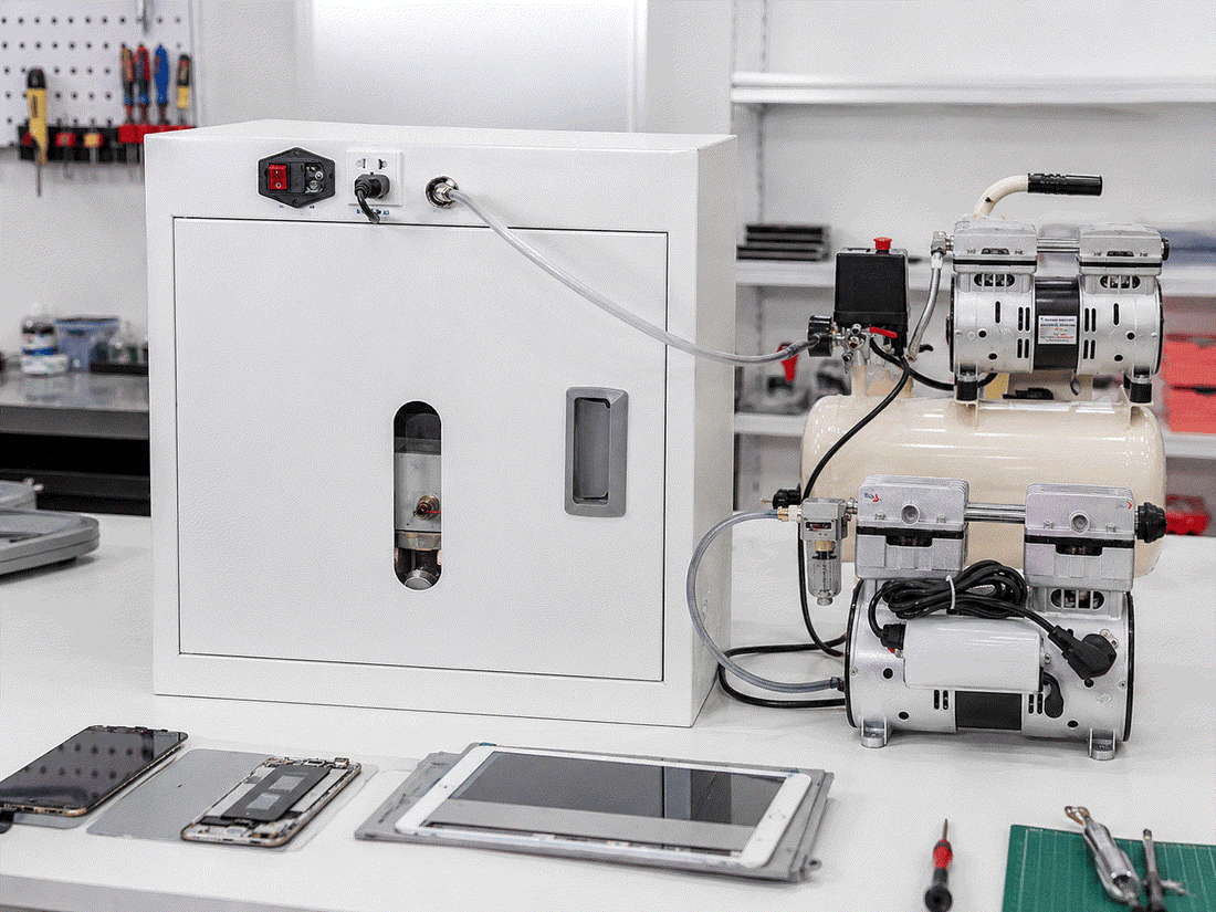 OCA vacuum laminator connected to an external air compressor and vacuum pump in a phone and tablet repair workstation